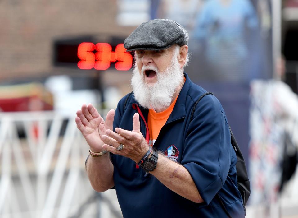Randy Mitchell, of Alabama, cheers on runners at the finish of the Sunday events of the 10th Canton Hall of Fame Marathon race weekend.