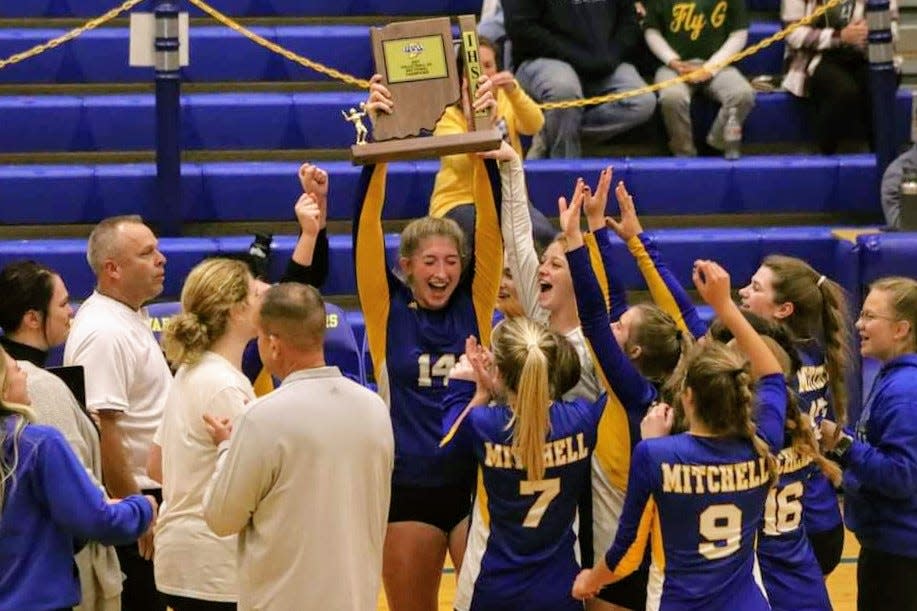 Maddie Robertson raises the sectional trophy after Mitchell defeated Christian Academy on Saturday.