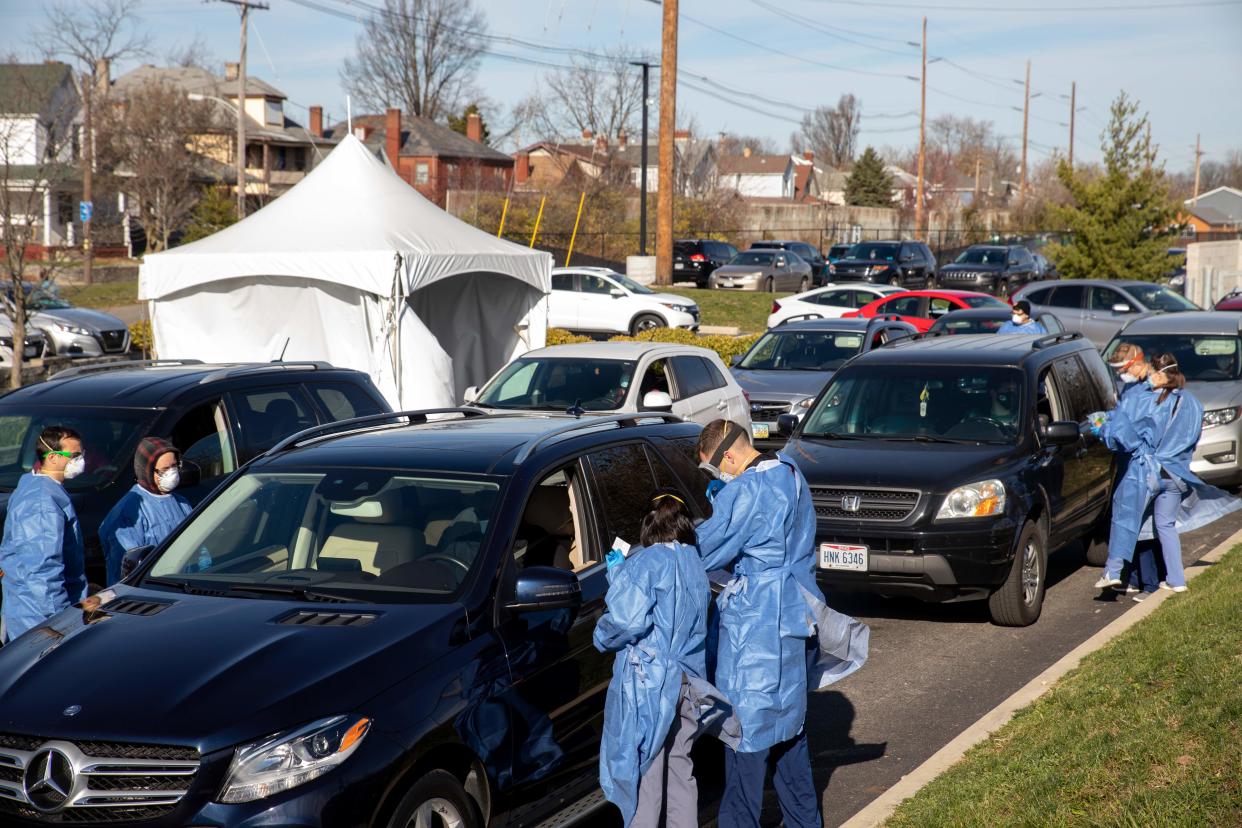 Healthcare workers administer free Covid-19 tests to people in their cars in the parking lot of the Columbus West Family Health and Wellness Center in Columbus, Ohio on November 19, 2020. (Photo by Stephen Zenner / AFP) (Photo by STEPHEN ZENNER/AFP via Getty Images)