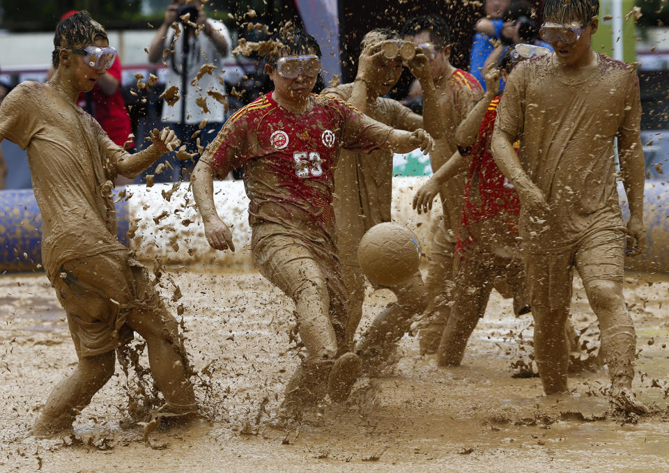 Competitors participate in a Swamp Soccer match in Beijing