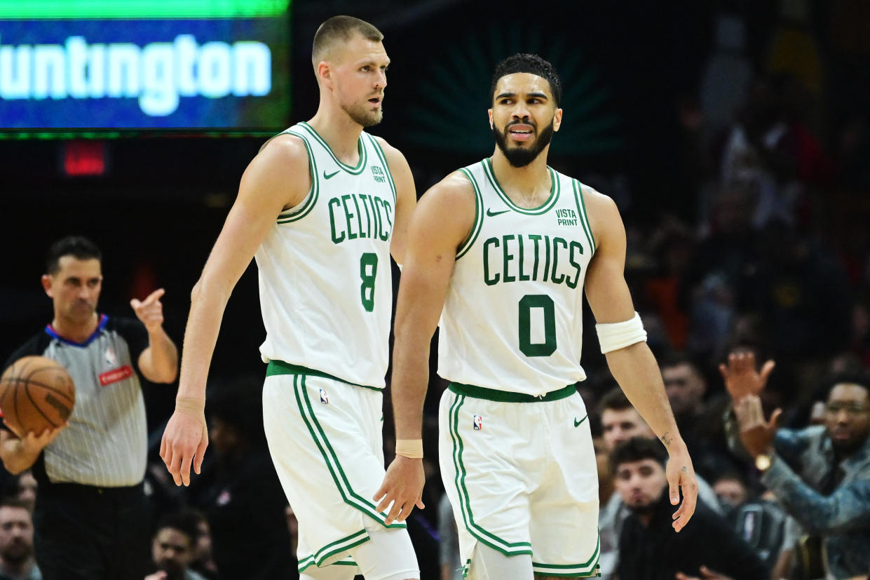 Mar 5, 2024; Cleveland, Ohio, USA; Boston Celtics center Kristaps Porzingis (8) and forward Jayson Tatum (0) react after a play during the second half against the Cleveland Cavaliers at Rocket Mortgage FieldHouse. Mandatory Credit: Ken Blaze-USA TODAY Sports