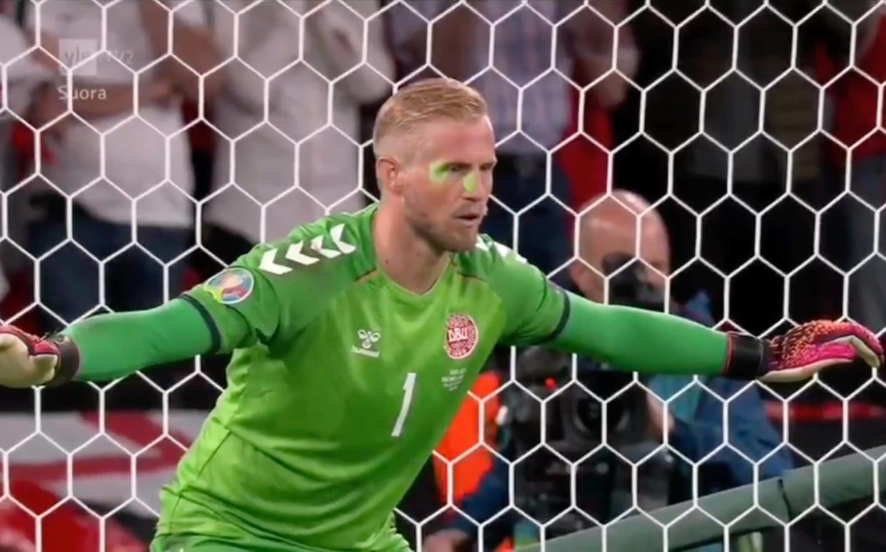 A laser pen shines on Kasper Schmeichel's face as he prepares to face Harry Kane's penalty