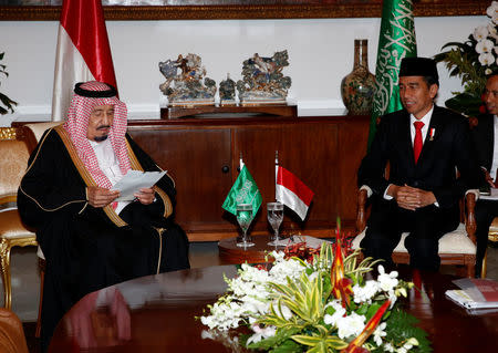 Saudi Arabia's King Salman reads documents as Indonesian President Joko Widodo looks on during their meeting at the Presidential Palace in Bogor, West Java, Indonesia March 1, 2017. REUTERS/Adi Weda