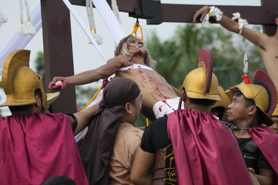 Actors carry Wilfredo Salvador during a reenactment of Jesus Christ's sufferings as part of Good Friday rituals April 7, 2023 in the village of San Pedro, Cutud, Pampanga province, northern Philippines. The real-life crucifixions, a gory Good Friday tradition that is rejected by the Catholic church, resumes in this farming village after a three-year pause due to the coronavirus pandemic.(AP Photo/Aaron Favila)