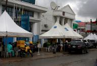 Customers sit under tent canopies outside the bank premises in area 8, in Abuja