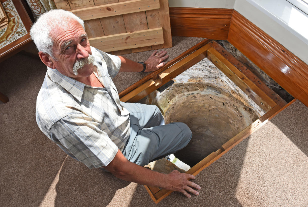 CATERS NEWS (PICTURED - Colin Steer sat on the edge of his well) - A grandad has spent the last decade digging out a 17ft deep medieval well in his living room after noticing a slight dip in the floor when redecorating. Colin Steer, from Plymouth, discovered the well after he noticed a dip in the floor while redecorating his living room ten years ago and has since spent the last decade digging out the 17ft well. The 70-year-old believes that the well could date back to medieval times after discovering an old sword while digging out the well and plans of the site suggests that the well could date back to the 1500s. Colin said: 