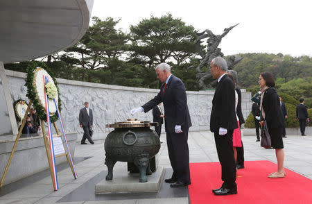 U.S. Vice President Mike Pence, left, burns incense at the National Cemetery in Seoul, South Korea, Sunday, April. 16, 2017. REUTERS/Ahn Young-joon/Pool