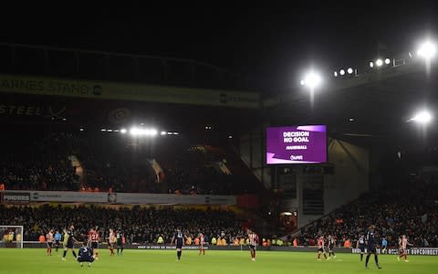 The big screen shows the VAR decision ruling out a goal by West Ham United's Scottish midfielder Robert Snodgrass because of a handball in the build up during the English Premier League football match between Sheffield United and West Ham United  - Credit: AFP