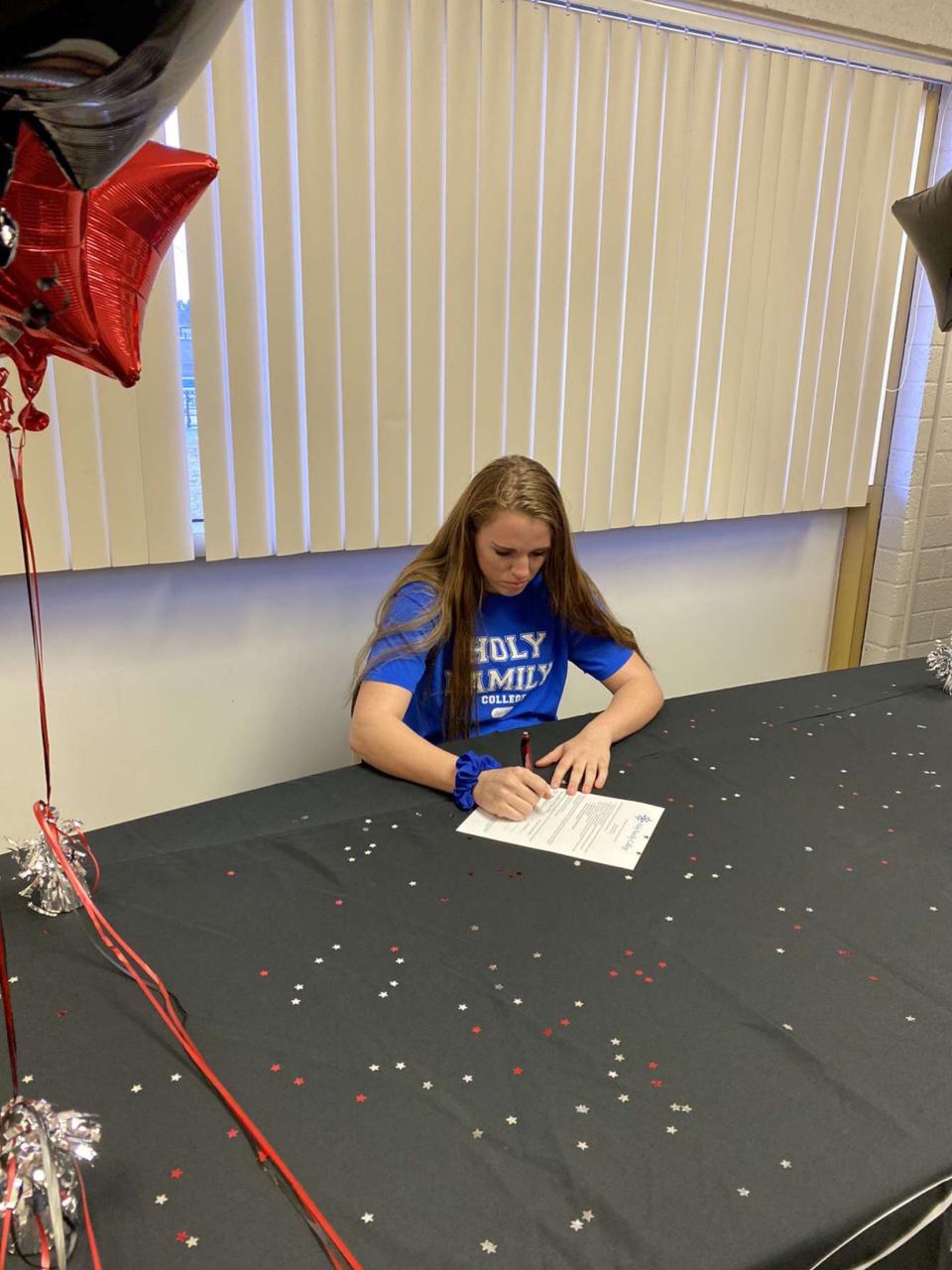 McKynna Bungard signs her letter of intent to play basketball at Holy Family College in Manitowoc. The college announced it will close by the end of the summer, leaving Bungard unsure of where she'll end up next.