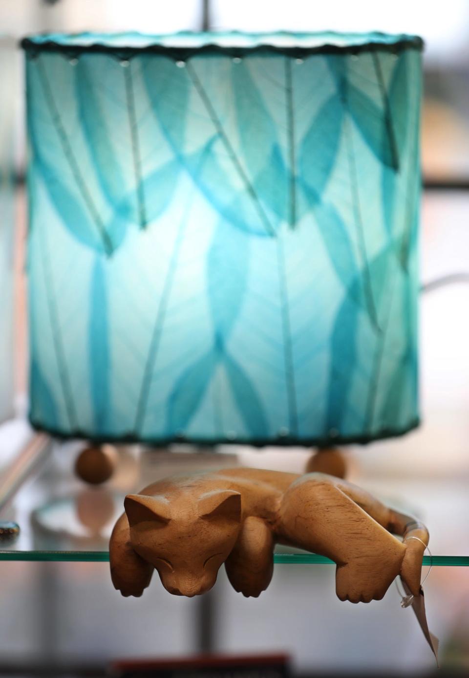 A lamp with a dyed leaf lamp shade from the Philippines and a cat sculpture from Indonesia are available at The Market Path in Copley.