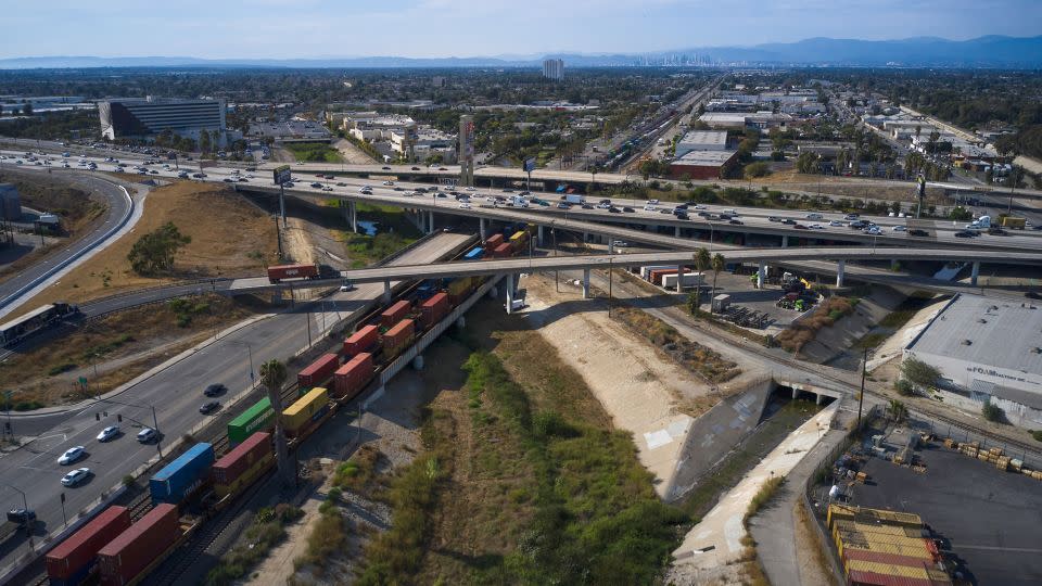 A long line of freight containers passes under a highway in Compton, California, US, on Tuesday, Aug. 2, 2022. - Bing Guan/Bloomberg/Getty Images