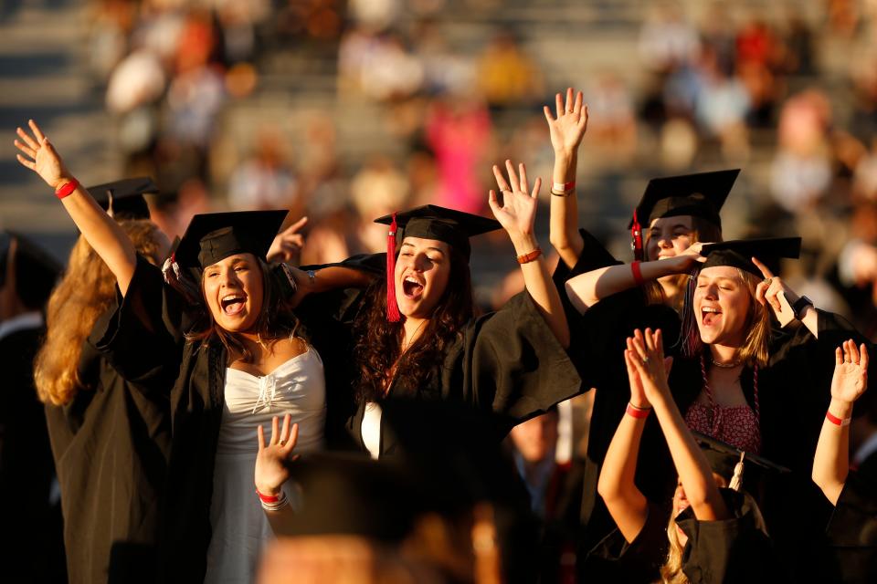 Graduates celebrate during the University of Georgia's spring undergraduate commencement at Sanford Stadium in Athens, Ga, on Thursday, May 13, 2021. A new study shows that those with a bachelor's degree from the Class of 2021 can earn as much as $1 million more in their lifetimes than those without a degree.