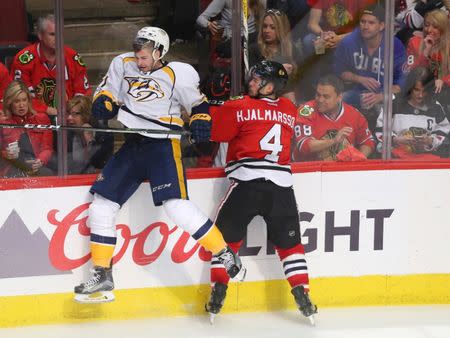 Apr 15, 2017; Chicago, IL, USA; Nashville Predators left wing Austin Watson (51) is checked by Chicago Blackhawks defenseman Niklas Hjalmarsson (4) during the third period in game two of the first round of the 2017 Stanley Cup Playoffs at the United Center. Nashville won 5-0. Mandatory Credit: Dennis Wierzbicki-USA TODAY Sports