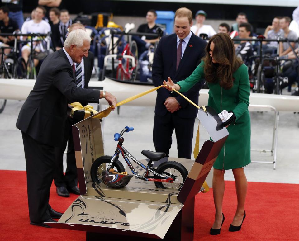 Britain's Prince William and his wife Catherine, Duchess of Cambridge, are presented with a bicycle for Prince George during a visit to open the new National Cycling Centre of Excellence, also known as the Avantidrome, in Cambridge April 12, 2014. Britain's Prince William and his wife Kate are undertaking a 19-day official visit to New Zealand and Australia with their son George. REUTERS/Phil Noble (NEW ZEALAND - Tags: ROYALS ENTERTAINMENT POLITICS SPORT CYCLING TPX IMAGES OF THE DAY)