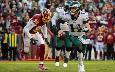 Philadelphia Eagles quarterback Carson Wentz (11) avoids the rush by Washington Redskins linebacker Montez Sweat (90) during the second half at FedExField - Credit: USA Today