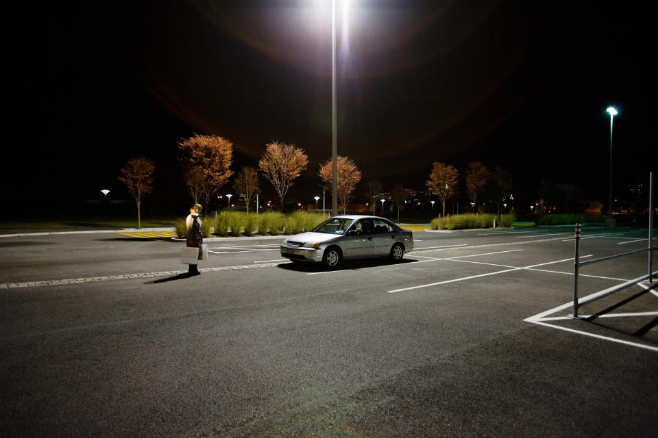 a lone car in a parking lot at night