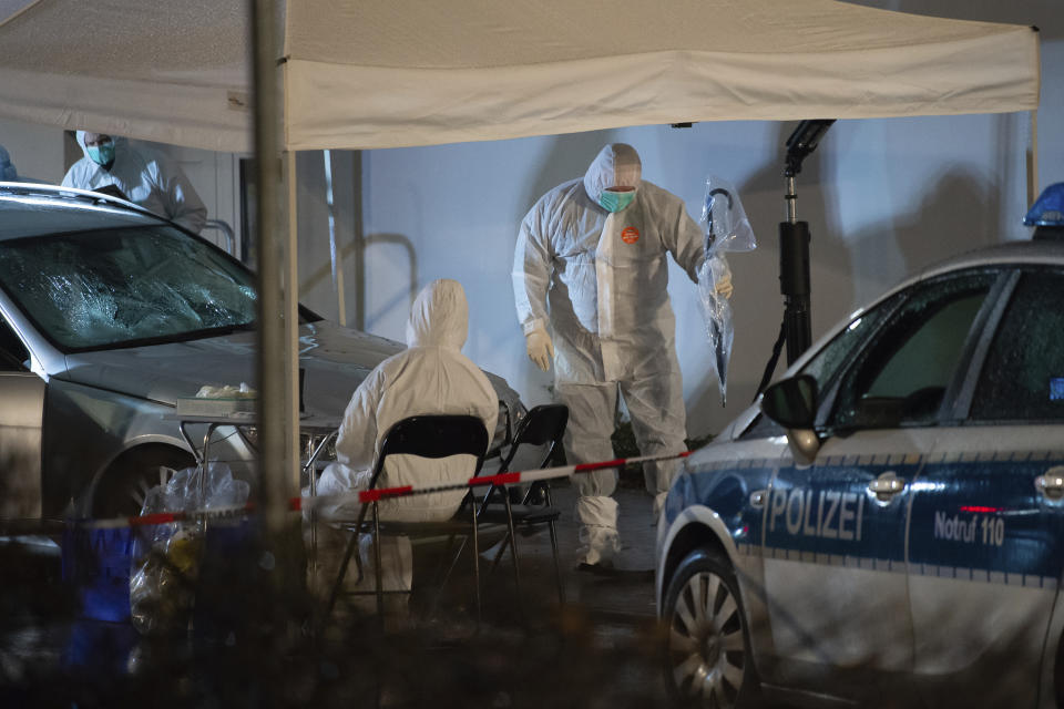 Investigating officers stand by a car that had driven into a crowd of people during a carnival procession in Volkmarsen, Germany, Monday, Feb. 24, 2020. A man intentionally drove a car into a crowd of people at a Carnival parade in a small town in central Germany, injuring dozens of people including children, officials said Monday. Prosecutors said the driver, a 29-year-old local man, was arrested at the scene of the incident in Volkmarsen, about 280 kilometers (175 miles) southwest of Berlin. (Swen Pfortner/dpa via AP)