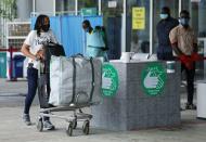 A passenger wearing a face mask pushes a trolley outside the Nnamdi Azikiwe International Airport in Abuja