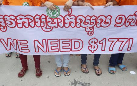 Garment workers hold a banner during a protest calling for higher wages in Phnom Penh September 17, 2014. REUTERS/Samrang Pring