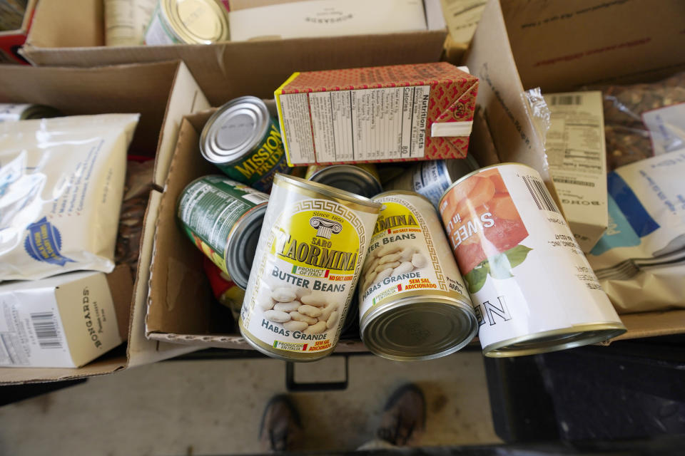 A variety of dry foods, powered milk, small blocks of cheese, canned vegetables, dried beans and apples are packed in individual boxes and readied to be distributed as part of the Mississippi SHINE Project, a program affiliated with the Jefferson County Community Health Center in Fayette, Miss., on Friday, March 12, 2021. Over 100 boxes of donated food were distributed within an hour to residents of one of the poorest counties in the state. (AP Photo/Rogelio V. Solis)