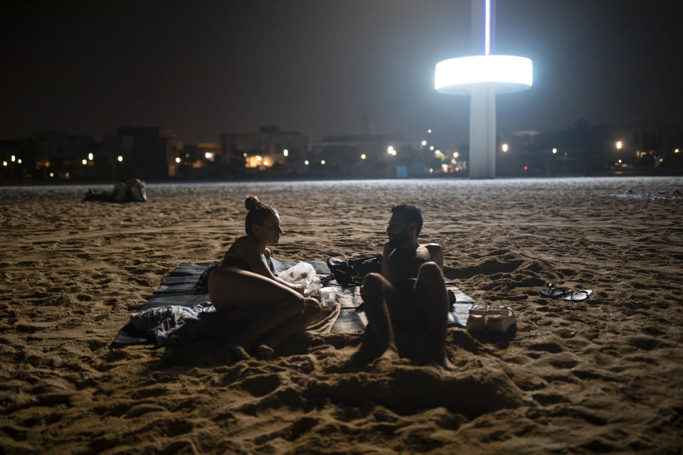 Grandes focos iluminan la playa nocturna de Umm Suqeim en Dubái, Emiratos Árabes Unidos, el 3 de agosto de 2023. (Andrea DiCenzo/The New York Times)