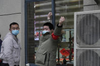 Security personnel blocks a window into the Service Center for Party Members and Residents of Jiangxinyuan Community where a World Health Organization team is making a field visit in Wuhan in central China's Hubei province on Thursday, Feb. 4, 2021. (AP Photo/Ng Han Guan)