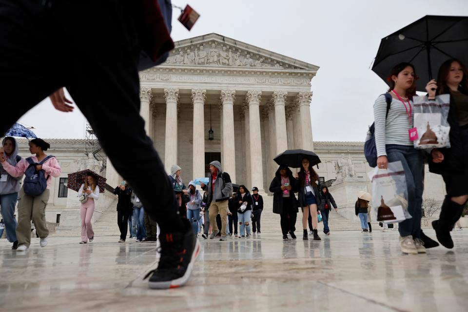 Tourists move through the plaza in front of the Supreme Court building April 7, 2023.