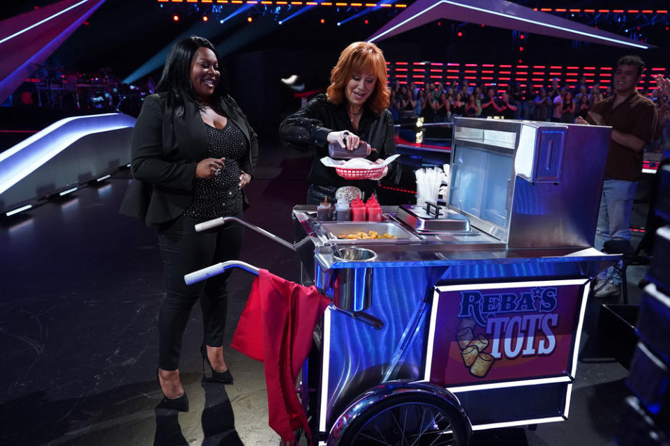 Reba McEntire hands out her signature tater tots to Ms. Monet and other new Team Reba members. (Tyler Golden/NBC)