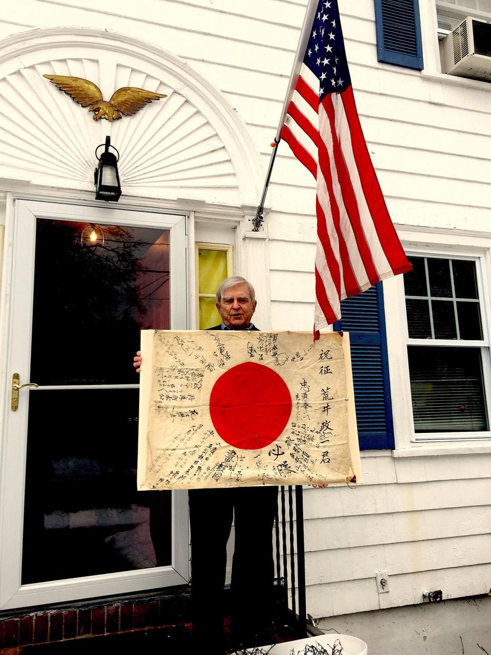 Frank Lennon holds the "good luck" flag he is trying to return to the owner's family in Japan.