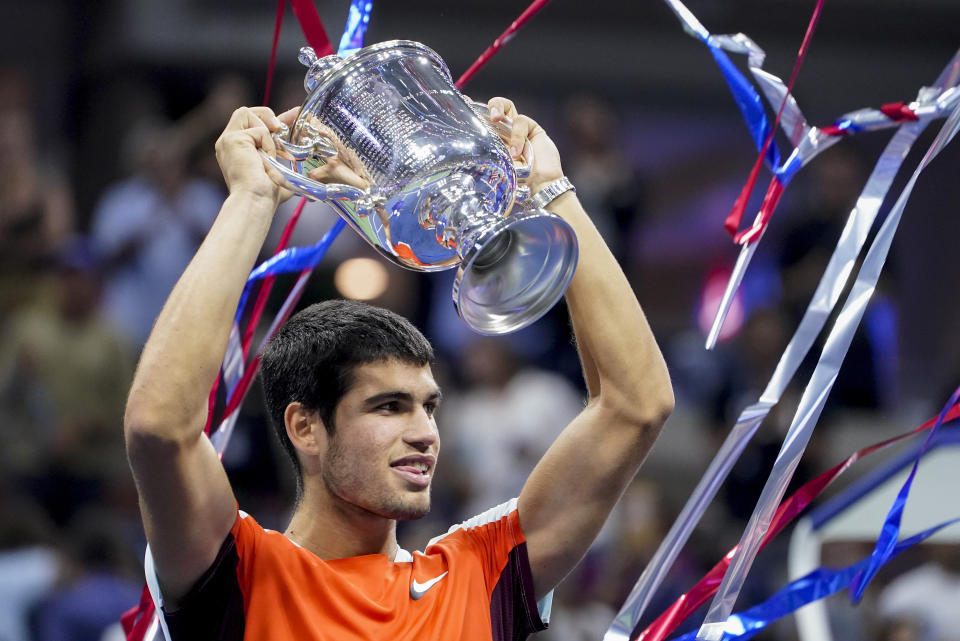 Carlos Alcaraz, of Spain, holds up the championship trophy after defeating Casper Ruud, of Norway, in the men's singles final of the U.S. Open tennis championships, Sunday, Sept. 11, 2022, in New York. (AP Photo/John Minchillo)