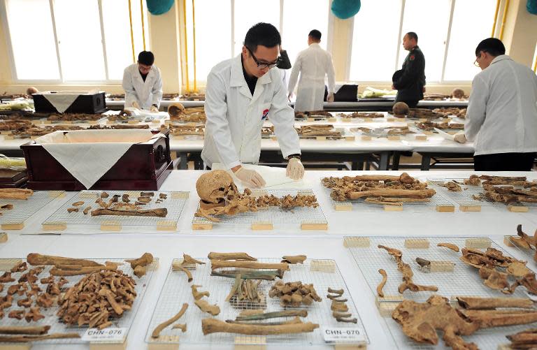 South Korean soldiers prepare the remains of Chinese war dead before placing them in a coffin in Paju, on March 17, 2014