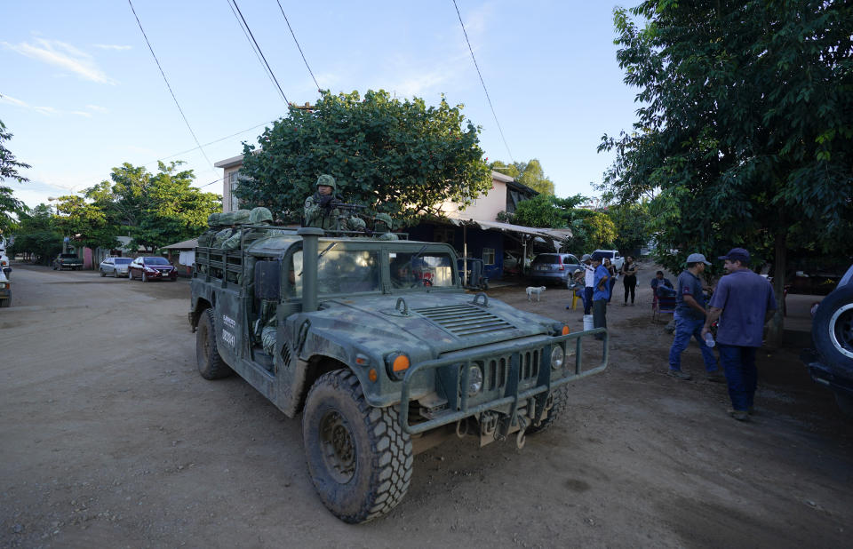 Soldiers patrol in the hamlet Plaza Vieja, in the Michoacan state of Mexico, Thursday, Oct. 28, 2021. The Mexican army has largely stopped fighting drug cartels here, instead ordering soldiers to guard the dividing lines between gang territories so they won’t invade each other’s turf — and turn a blind eye to the cartels’ illegal activities just a few hundred yards away. (AP Photo/Eduardo Verdugo)