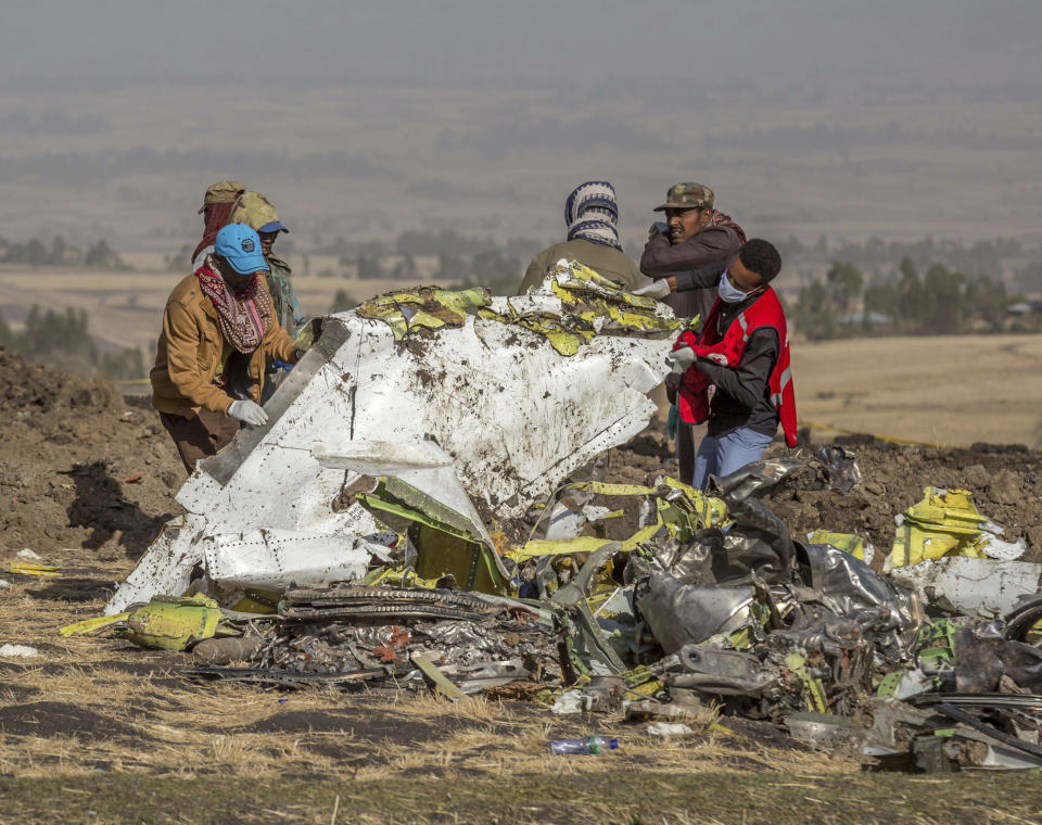 Rescuers work at the scene of an Ethiopian Airlines flight crash near Bishoftu, or Debre Zeit, south of Addis Ababa,  Ethiopia, Monday, March 11, 2019. A spokesman says Ethiopian Airlines has grounded all its Boeing 737 Max 8 aircraft as a safety precaution, following the crash of one of its planes in which 157 people were killed. (AP Photo/Mulugeta Ayene)