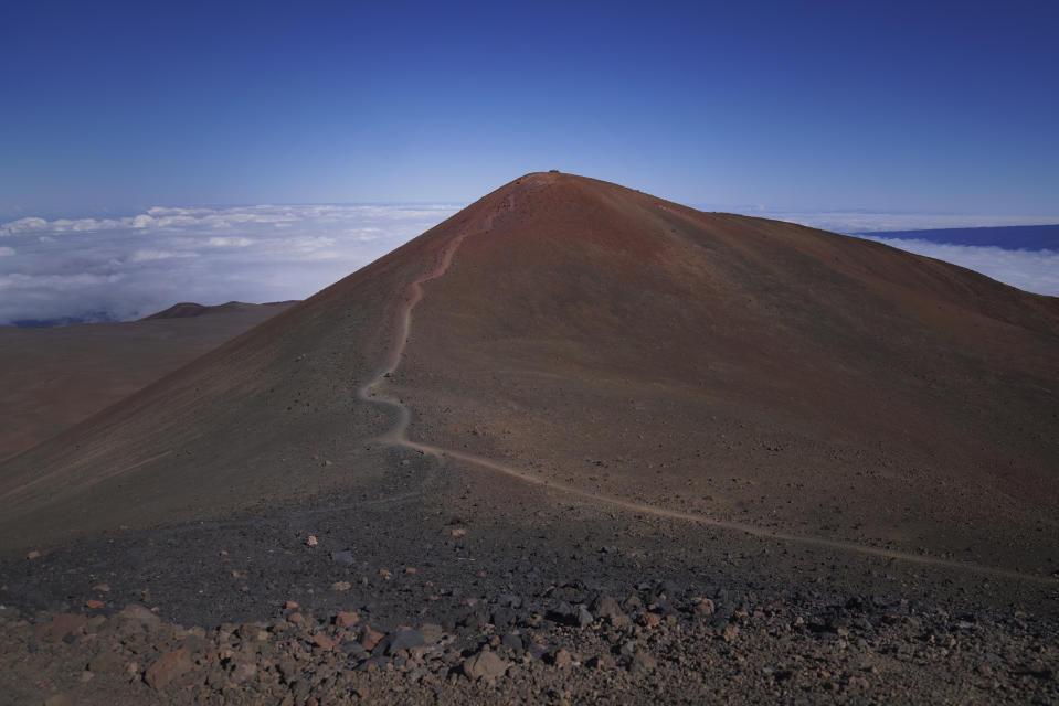 A foot trail leads to an "ahu," or ceremonial platform atop Pu'u Wekiu, an important summit to many Native Hawaiian cultural practitioners, on the sacred mountain Mauna Kea in Hawaii on Saturday July, 15, 2023. Along the slopes of this sacred mountain are ceremonial platforms, ancestral burial sites, and an alpine lake whose waters are believed to have healing properties. (AP Photo/Jessie Wardarski)