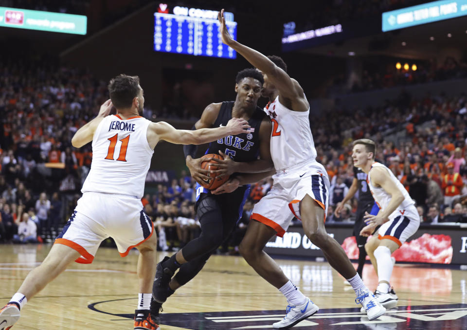 Duke forward RJ Barrett (5) splits two Virginia defenders during the first half of an NCAA college basketball game Saturday, Feb. 9, 2018, in Charlottesville, Va. (AP Photo/Zack Wajsgras)