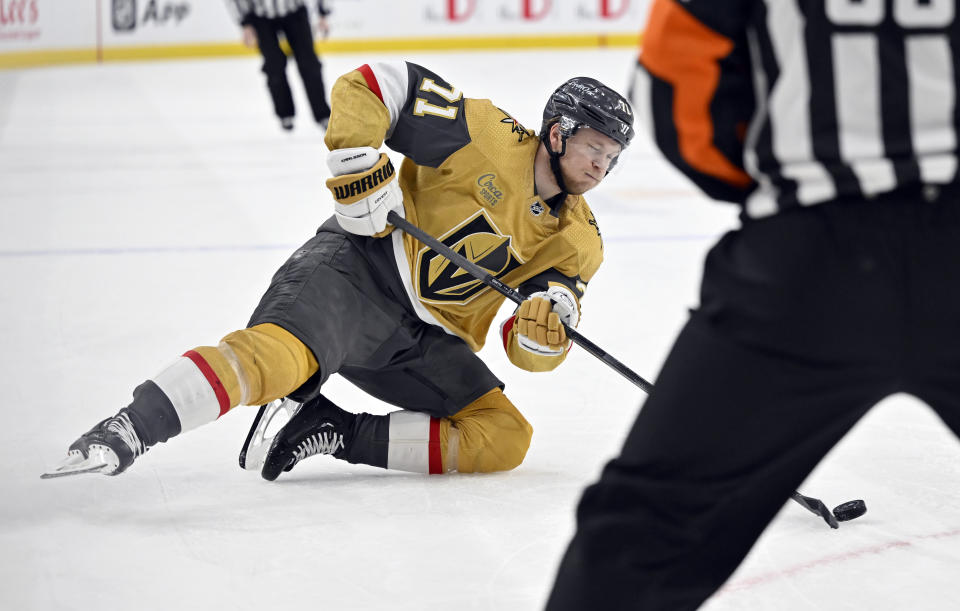 Vegas Golden Knights center William Karlsson (71) slides on the ice as he passes the puck against the Dallas Stars during the second period of an NHL hockey game Saturday, Feb. 25, 2023, in Las Vegas. (AP Photo/David Becker)