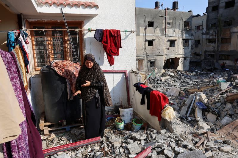 Una mujer palestina tiende la ropa en su casa, dañada durante los combates entre Israel y Gaza, durante un alto el fuego, en la ciudad de Gaza