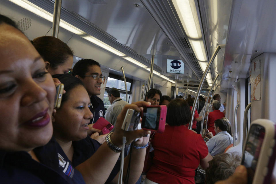 En esta imagen del miércoles 2 de abril de 2014, empleados del gobierno y sus invitados entran a un tren del metro como parte de una actividad para probar los vagones del nuevo metro de la capital panameña, el primero de Centroamérica. (Foto AP/Arnulfo Franco)