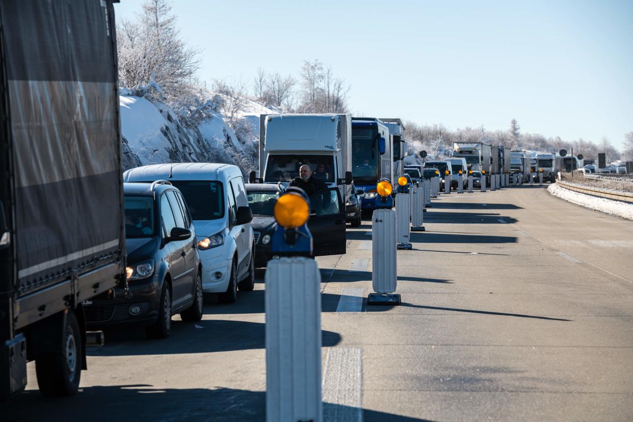 Vehicles wait at a checkpoint of the Federal Police at the German-Czech border near Breitenau, eastern Germany on February 14, 2021. - Germany implemented more measures to keep coronavirus variants at bay, banning travel from Czech border regions and Austria's Tyrol after a troubling surge in contagious mutations. (Photo by JENS SCHLUETER / AFP) (Photo by JENS SCHLUETER/AFP via Getty Images)