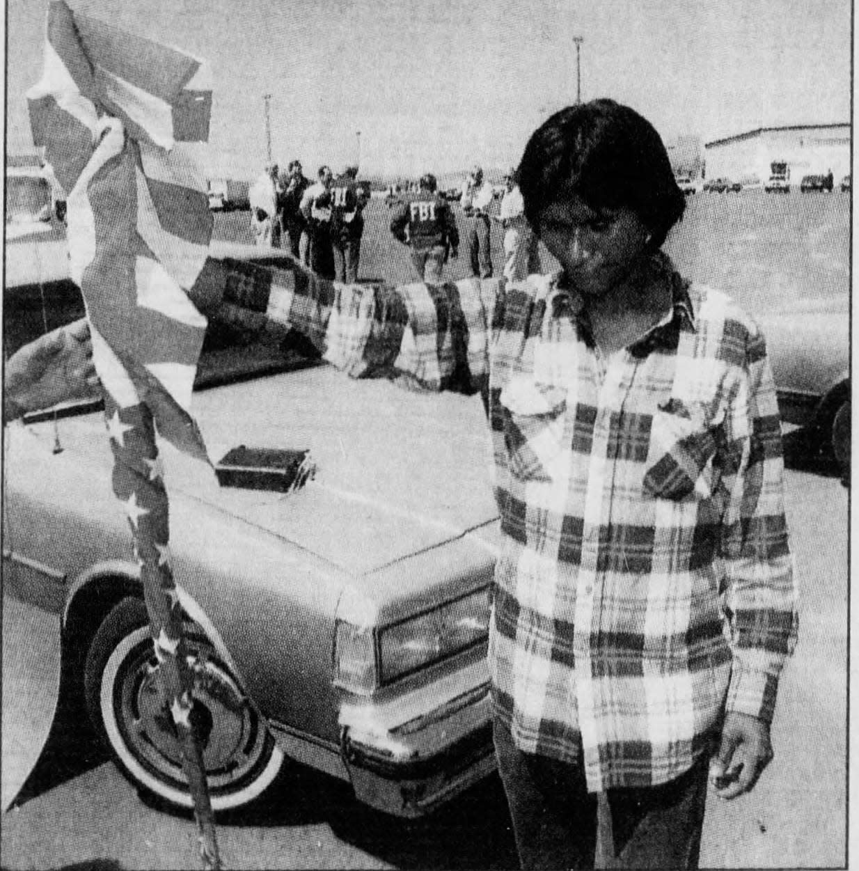 Nolan Thomas creates a distress signal by holding an American flag upside down during an FBI raid of an Arizona Native American casino, May 13, 1992.