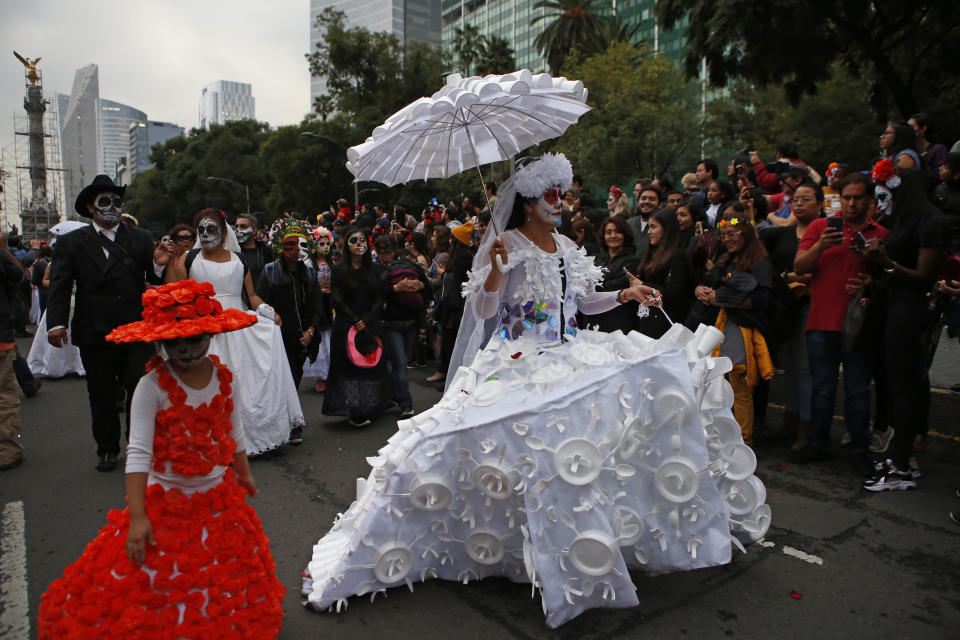 People dressed as Catrinas parade down Mexico City's iconic Reforma avenue during celebrations for the Day of the Dead in Mexico, Saturday, Oct. 26, 2019. (AP Photo/Ginnette Riquelme)