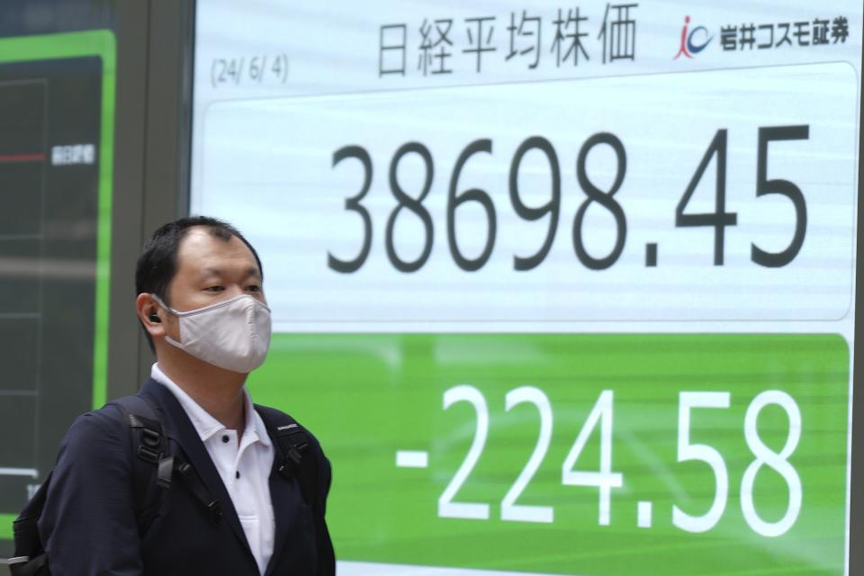 A person walks in front of an electronic stock board showing Japan's Nikkei 225 index at a securities firm Tuesday, June 4, 2024, in Tokyo. (AP Photo/Eugene Hoshiko)