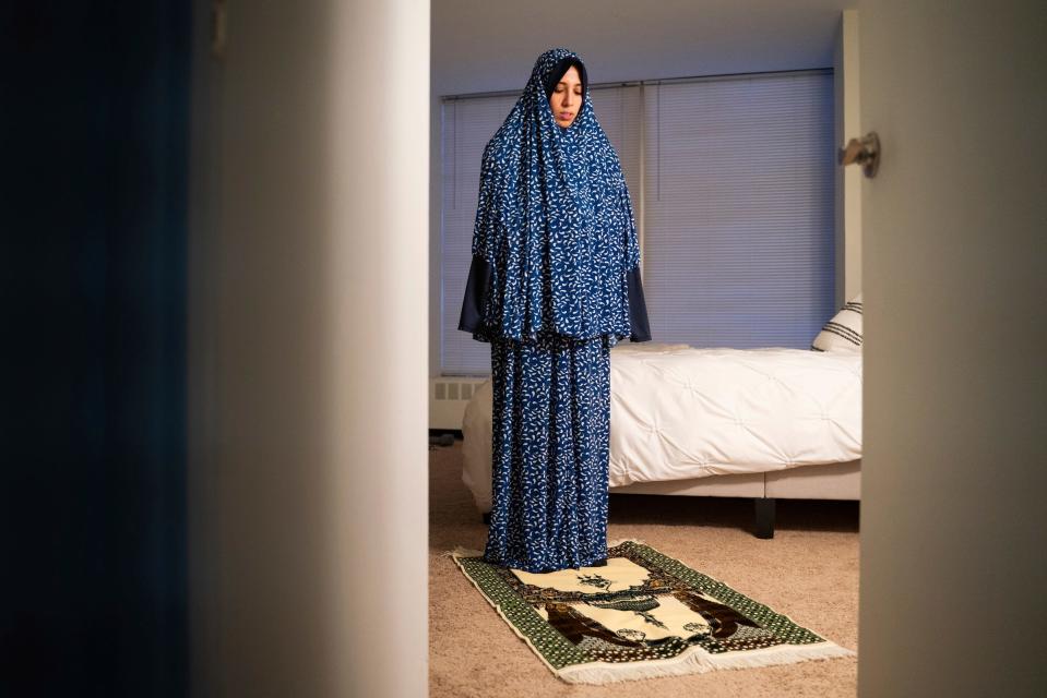 Detroit Free Press reporter Dana Afana, 31, prays at the start of Iftar, a fast-breaking meal eaten after sunset, during Ramadan on Tuesday, March 28, 2023.