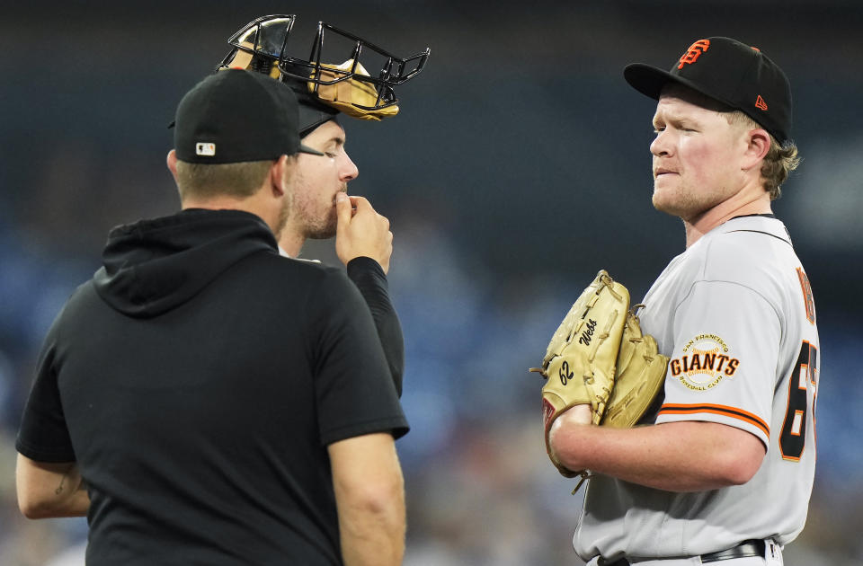 San Francisco Giants starting pitcher Logan Webb, right, is visited on the mound by catcher Patrick Bailey during the first inning of the team's baseball game against the Toronto Blue Jays on Wednesday, June 28, 2023, in Toronto. (Frank Gunn/The Canadian Press via AP)