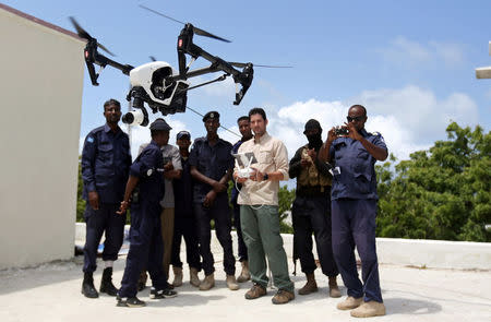 Somali police officers watch instructor Brett Velicovich fly a DJI Inspire drone during a drone training session for Somali police in Mogadishu, Somalia May 25, 2017. Picture taken May 25, 2017. REUTERS/Feisal Omar