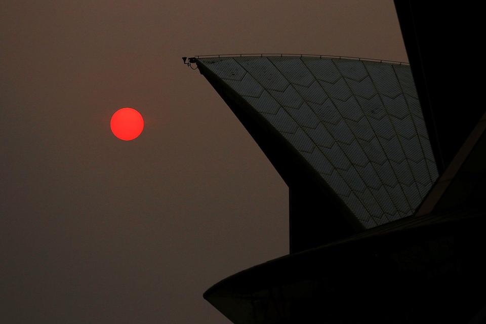 The sun is seen through bushfire haze next to the Sydney Opera House in Sydney, Australia, on Dec. 19, 2019. 