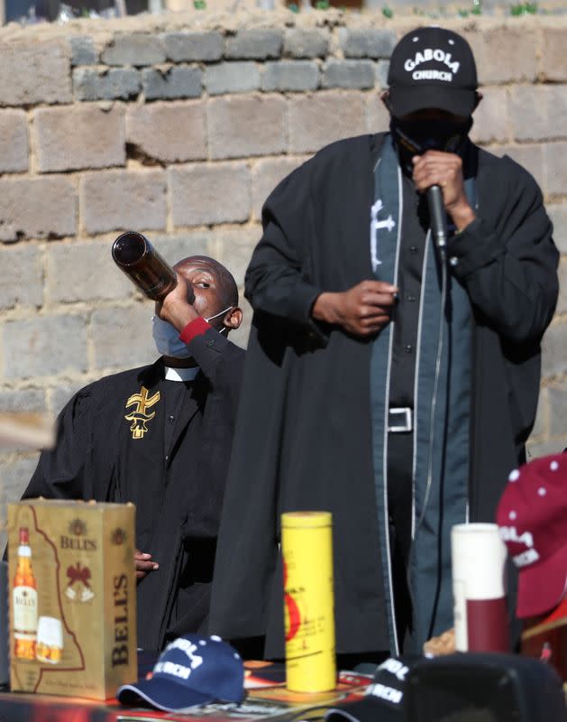 A clergyman of the Gabula church drinks beer during a "church service\