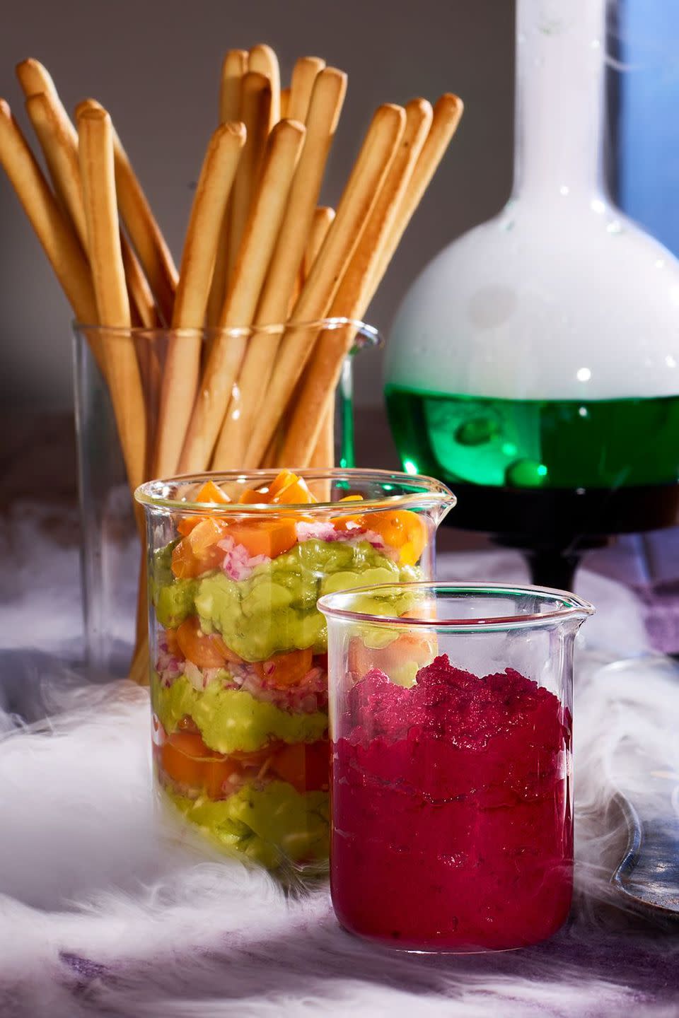 <p>Presentation is everything. This mad scientist display for guacamole, beet hummus, romesco, and bread dips will get guests talking. </p><p><a class="link " href="https://www.amazon.com/Glass-Measuring-Beaker-100ml-Graduated/dp/B01J57WFF6?tag=syn-yahoo-20&ascsubtag=%5Bartid%7C10070.g.2574%5Bsrc%7Cyahoo-us" rel="nofollow noopener" target="_blank" data-ylk="slk:Shop Beakers">Shop Beakers</a></p>