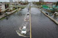 <p>Cars drive through a flooded road in the aftermath of Hurricane Maria in San Juan, Puerto Rico, on Sept. 21, 2017. (Photo: Ricardo Arduengo/AFP/Getty Images) </p>