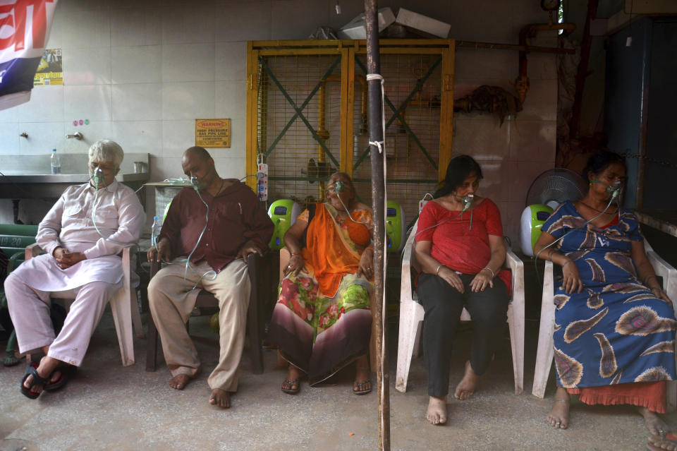 COVID-19 patients receive oxygen outside a Gurdwara, a Sikh house of worship, in New Delhi, India, Saturday, May 1, 2021. India on Saturday set yet another daily global record with 401,993 new cases, taking its tally to more than 19.1 million. Another 3,523 people died in the past 24 hours, raising the overall fatalities to 211,853, according to the Health Ministry. Experts believe both figures are an undercount. (AP Photo/Amit Sharma)